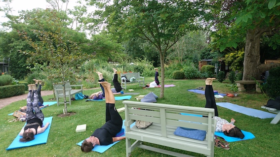 Group class practising yoga in St Ethelwold's garden